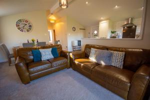 a living room with two brown leather couches at Y Caban in Cemaes Bay