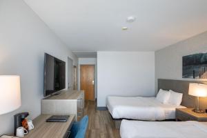 une chambre d'hôtel avec deux lits et un bureau dans l'établissement Repotel Henri IV Québec, à Québec