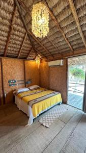 ein Schlafzimmer mit einem Bett in einem Zimmer mit einem Kronleuchter in der Unterkunft Casa Lua Barrinha in Barrinha