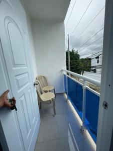 un balcón con una puerta blanca y una silla en Apartamento acogedor a 5 minutos de la playa, en San Felipe de Puerto Plata