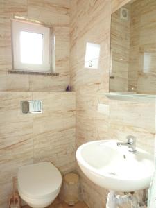 a bathroom with a white sink and a toilet at Elizabeth Łeba - Domki Letniskowe & Studia in Łeba +57 photos