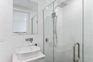 a white bathroom with a sink and a shower at Lakeview Luxury Villa in Wanaka