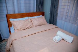 a bed with a roll of toilet paper on it at Raha Harmony Hideout in Dar es Salaam +10 photos
