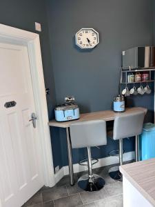 a kitchen with a table and a clock on the wall at Art Deco One Bedroom Guest Apartment in Yapton +10 photos