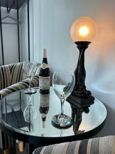 a bottle of wine and two wine glasses on a table at Art Deco One Bedroom Guest Apartment in Yapton