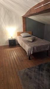 a bedroom with a bed and a lamp on a wooden floor at Maison Girondine 4 personnes in Saint-Seurin-de-Bourg +7 photos