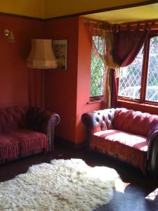 a living room with two couches and a white rug at Newcourt B & B in Llantwit Major