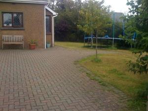 a brick driveway with a bench in front of a house at Newcourt B & B in Llantwit Major