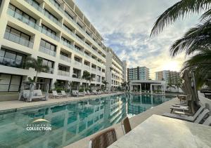 a hotel swimming pool with chairs and a building at Residence by Mio Nuevo Vallarta 103-C in Nuevo Vallarta