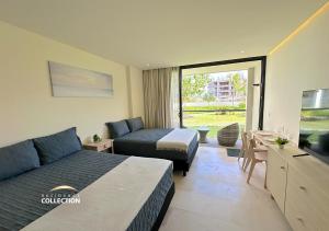 a hotel room with two beds and a couch at Residence by Mio Nuevo Vallarta 103-C in Nuevo Vallarta +22 photos