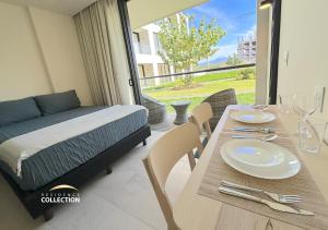 a room with a bed and a table with plates and glasses at Residence by Mio Nuevo Vallarta 103-C in Nuevo Vallarta