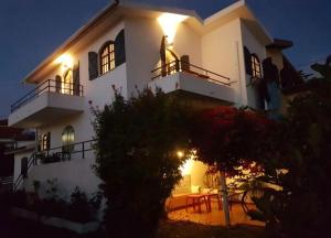 a large white house with lights on the side of it at Equinoxea in Nazaré