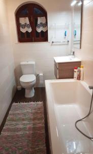 a bathroom with a toilet and a sink and a tub at Equinoxea in Nazaré