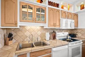 a kitchen with white cabinets and a sink at Menehune Shores 606 in Kihei