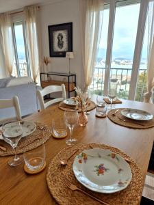een eettafel met borden en glazen erop bij Appartement Ajaccio vue mer in Ajaccio +10 foto's
