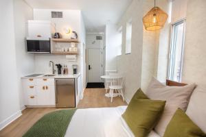 a bedroom with a bed and a small kitchen at Studio #18 - Self Check-In - Plateau - St-Denis in Montreal