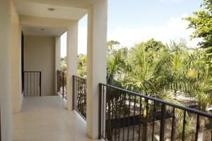 a balcony of a house with palm trees at Casona de la Guayabera Hospedaje in Tekit
