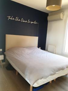 a bed with a sign that reads take the time to build at Welcome Villa 8p moderne Terrasse Jacuzzi Jardin in LʼHay-les-Roses +17 photos