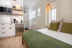a bedroom with a large bed with a green blanket at Studio #18 - Self Check-In - Plateau - St-Denis in Montreal +21 photos