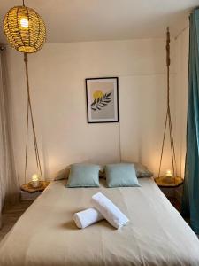 a bedroom with a bed with two towels on it at Le Canard du Berry - Wifi - Centre Ville in Bourges