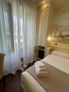 a bedroom with a bed with two towels on it at Dama Opera Elegantia Rooms in Rome