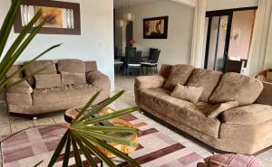 a living room with two couches and a table at CHACARA THA&THI COND FECHADO WI FI SPA e PISC AQUECECIMENTO SOLAR in Bom Jesus dos Perdões
