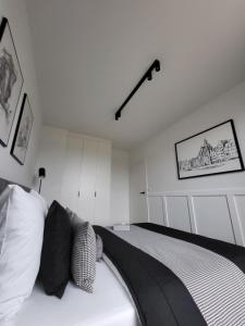 a bedroom with a bed with a black and white blanket at Apartament 150 Zaspa VVita z ogrodem i tarasem in Gdańsk