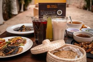 a table topped with plates of food and drinks at Casona de la Guayabera Hospedaje in Tekit