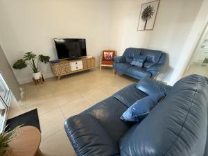 a living room with a blue couch and a tv at Marine Parade Holiday Unit 2 in Port Vincent