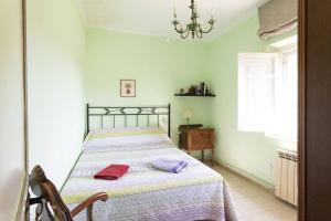 a bedroom with a bed and a chair and a window at S&C Apartments in Ilha da Madeira
