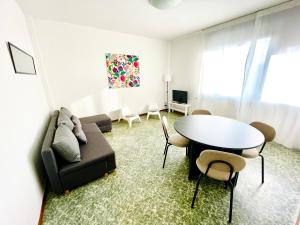 斯基奥Mamisà App centro Schio, parcheggio coperto的带沙发和桌子的客厅