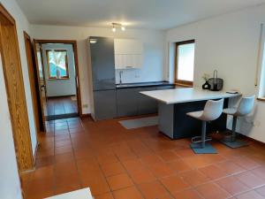 a kitchen with a counter and chairs in a room at Gemütliche Wohnung in Oberteuringen in Oberteuringen