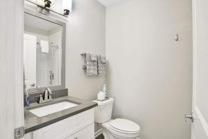 a white bathroom with a sink and a toilet at New Renovated 1 BR downtown apt in Mobile