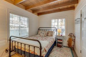 Un dormitorio con una cama y dos ventanas. en Walkable Green Gables Cottage in Lake Arrowhead, en Lake Arrowhead
