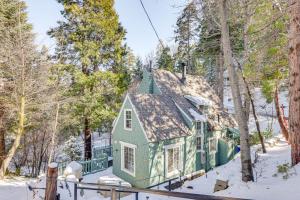 una casa verde en el bosque en la nieve en Walkable Green Gables Cottage in Lake Arrowhead, en Lake Arrowhead