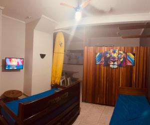 a bedroom with a surfboard hanging on the wall at Chalé Privativo Surfers Itaguá in Ubatuba