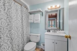 Un baño con inodoro, lavabo y espejo. en Oceanfront Inn Room #8 - Partial Ocean View - King Bed, en Fort Pierce