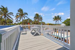 a boardwalk leading to the beach with a picnic table at Oceanfront Inn Room #5 - Standard Room - King Bed in Fort Pierce