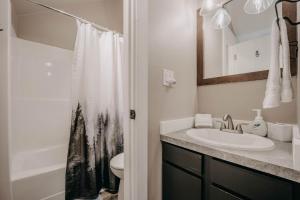 a bathroom with a sink and a toilet and a mirror at Snowater Condo 45SW with a Media Room in Deming +19 photos