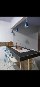 a dining table with two chairs and two blue lights at Residencial Franco Casa 02 in Primavera do Leste +3 photos