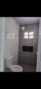 a bathroom with a toilet and a window at Residencial Franco Casa 02 in Primavera do Leste