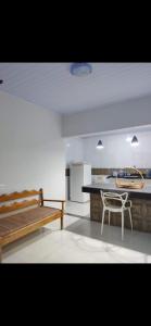 a kitchen with a table and a bench in a room at Residencial Franco Casa 02 in Primavera do Leste