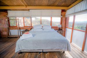 a bedroom with a bed in a room with windows at Hotel Casa Cantera in El Carmen