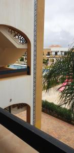 a view from the outside of a building with a palm tree at SALICORNE 1 marina saidia appt in Saïdia