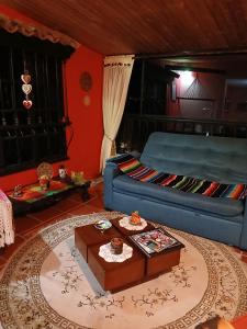 a living room with a blue couch and a table at Casa de la montaña El Pedregal de Sopó in Sopo