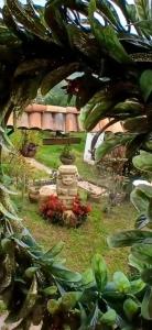 a garden with a statue and flowers in the grass at Casa de la montaña El Pedregal de Sopó in Sopo