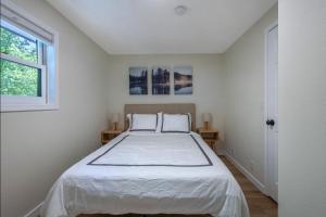 a white bedroom with a large bed with two pillows at Orchard Haven Combo in Lyle