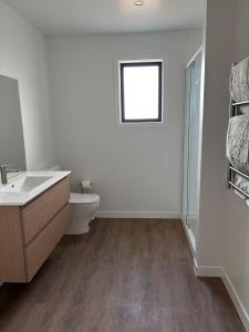 a bathroom with a sink and a toilet and a window at River Terrace Retreat Cromwell in Cromwell +14 photos