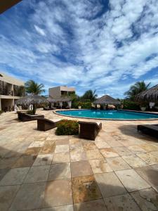 a swimming pool with umbrellas and a resort at Pousada Aruana in Canoa Quebrada