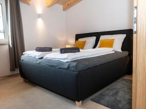 a black bed with pillows on it in a room at Tirolee Marchegg 2 OG Top 4 in Oberau